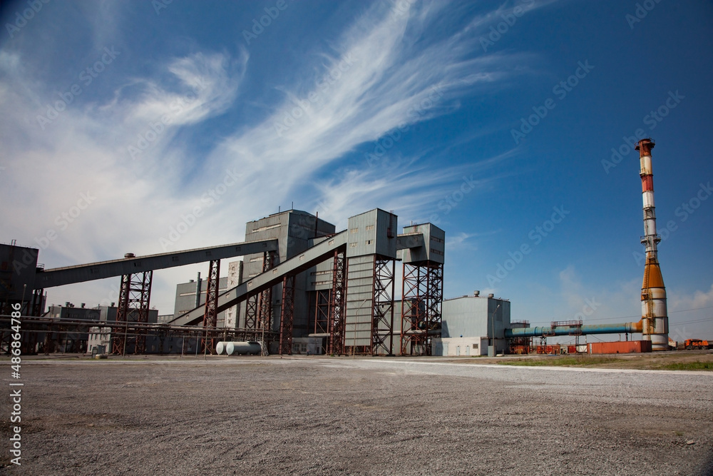 Metallurgy plant (smelter) industrial building. Blue sky with clouds background. Wide-angle view.