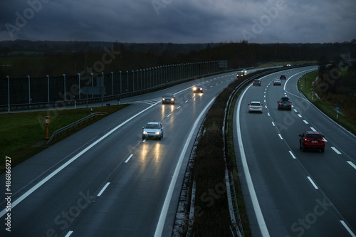 Driving cars on a wet highway at dusk under a cloudy sky in Germany, motion blur, copy space, selected focus