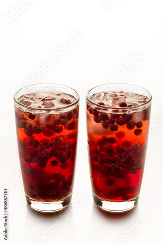 Cranberry juice with ice on a white background.