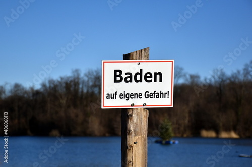 "Baden auf eigene Gefahr"-Schild an einem See