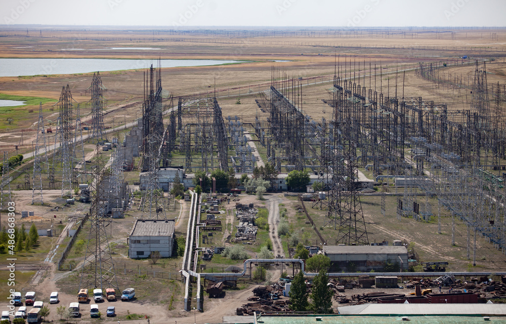 GRES-1 thermal power station. Transformer and distribution substation. Steppe and lake on background, blue sky.Aerial view. Ekibastuz, Pavlodar region, Kazakhstan.