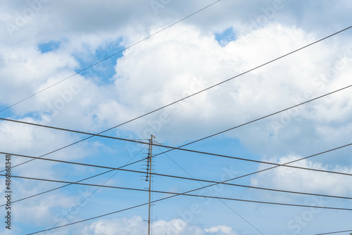 Intersecting wires with an antenna on a blue sky background