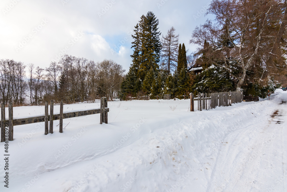 Meadow covered by snow in winter. Old wooden fence. Trees near. Meadow covered by snow in winter. Old wooden fence. Trees near.