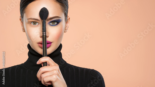 Photos Portrait of a girl with cosmetic brush at face