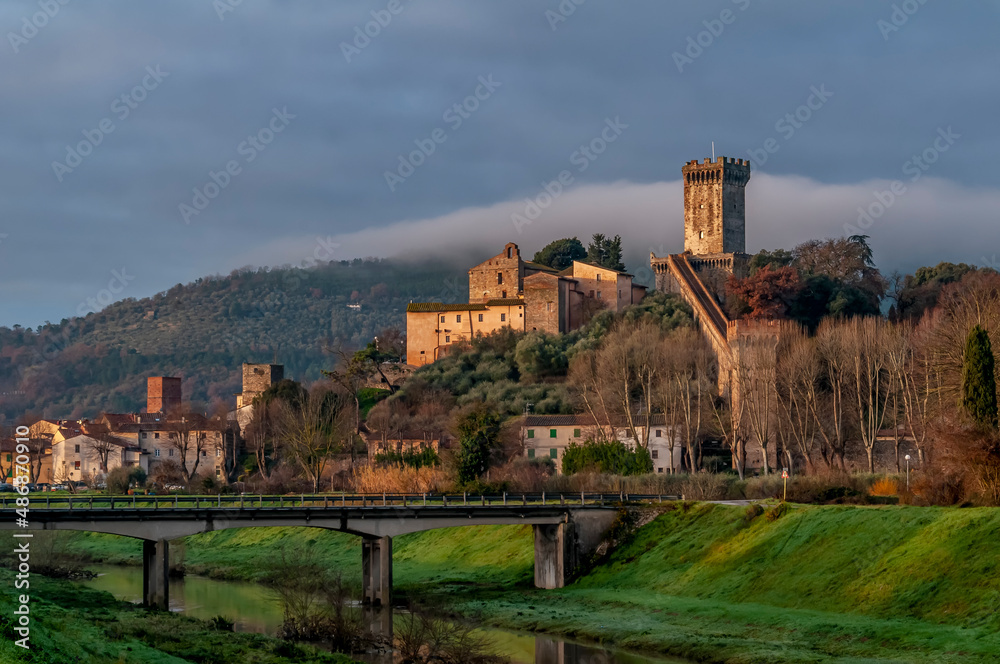 View of the historic center of Vicopisano, Italy, with fog over the surrounding mountains