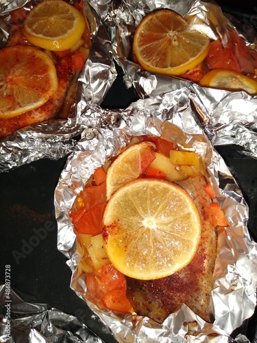 Fototapeta Naklejka Na Ścianę i Meble -  The process of cooking red trout fish with lemon and vegetables in foil. High quality photo