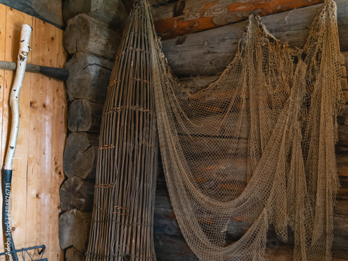 Fishing gear in a house built in the 19th century. Antique nets and wooden fishing basket for catching fish.
