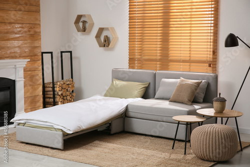 Room interior with sleeper sofa near fireplace
