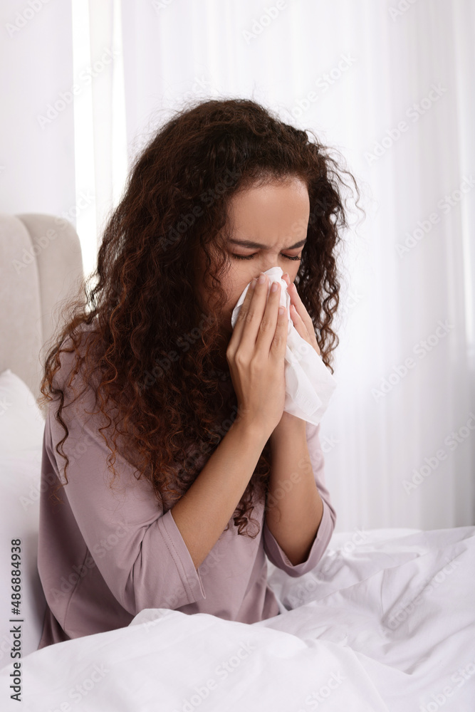 Sick African American woman with tissue in bed at home Sick African American woman with tissue in bed at home