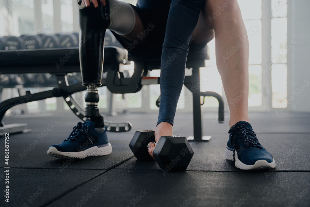 Obraz premium Close up of disabled man with prosthetic leg doing bicep curls