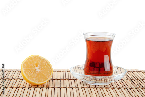 Glass of turkish tea and lemon on white background