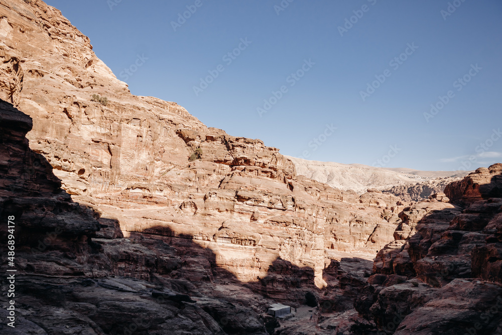 Ruins of the ancient city of Petra in Jordan. Red sandstone mountains on a clear day. Caves in the rock. Landscape. Colorful photos.