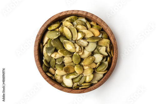 Pumpkin seeds on wooden bowl isolated on white background.