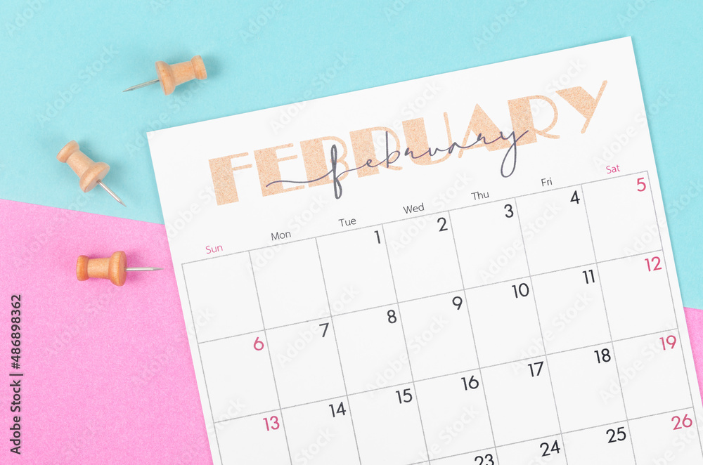 February 2022 calencar and wooden push pin on beautiful background.