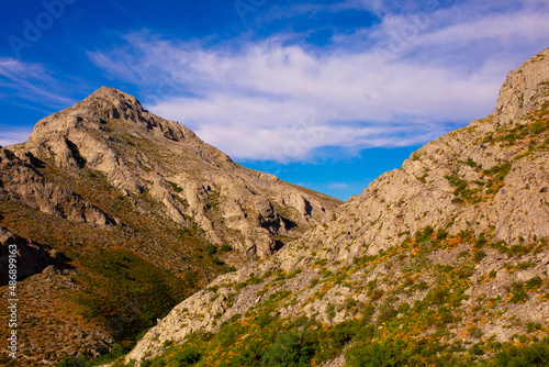 Beautiful nature of rocky mountains. Unusual landscape of nature. Trees among the rocks against the sky with clouds.