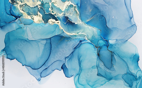 Abstract alcohol ink painting texture in blue azure tones with golden splashes