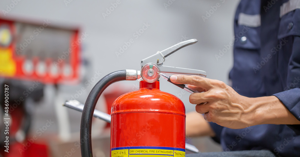 Engineer are checking and inspection a fire extinguishers tank in the fire control room for safety training and fire prevention.