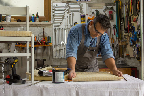 Man carpenter struggling with the restoration of old chairs. Craft work