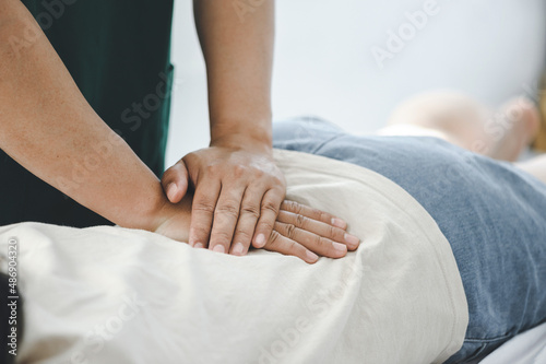 Doctor or physiotherapist helps to heal a young woman's back. and give advice within the rehabilitation center. Concept of physical rehabilitation.