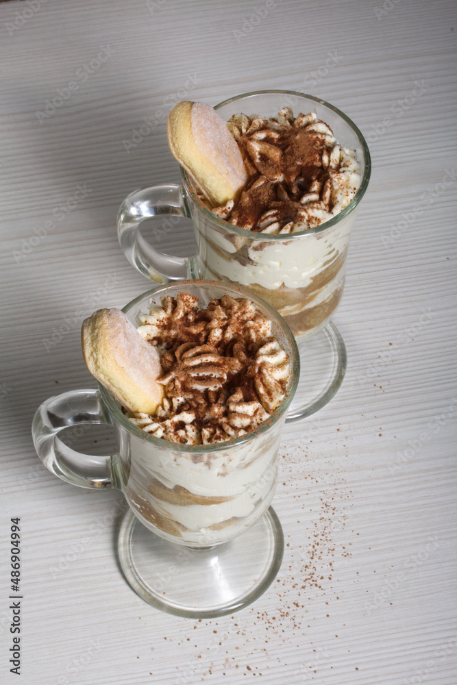 Dessert with Savoiardi cookies and cream. Tiramisu cookies. Close-up.