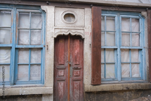 Vintage style door and window, Ottoman sultan's signature on top of wooden door and between two blue windows. © SKahraman