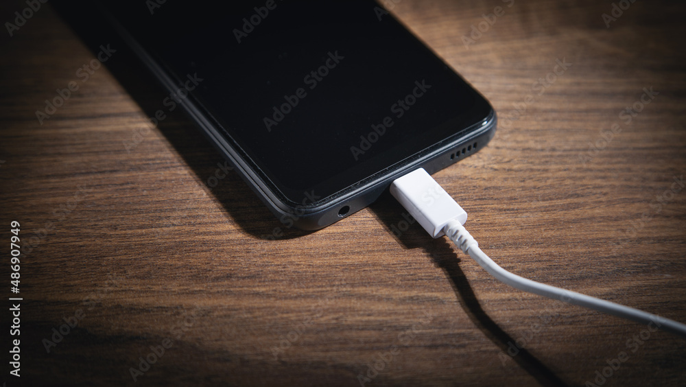 Smartphone charging battery on the wooden table. Smartphone charging battery on the wooden table.