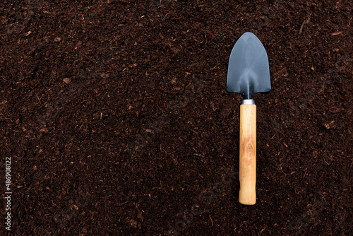 View from above on the garden blade lying on the ground. Gardening tools on a background of soil. Spring garden, Planting flowers in garden, Horticulture and gardening concept