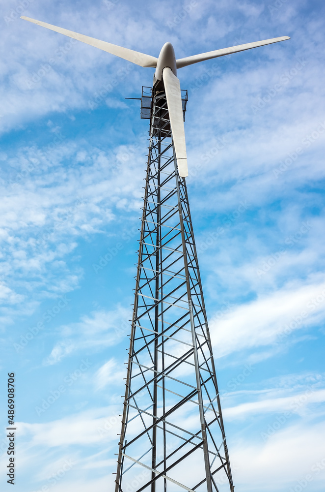 Wind turbine against a blue sky with light clouds. Russia, Orenburg region Wind turbine against a blue sky with light clouds. Russia, Orenburg region