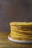 high stack of pancakes on a wooden background. Maslenitsa