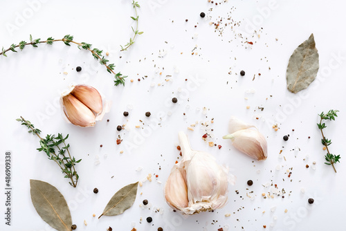 Different spices and garlic on light grey background, top view.