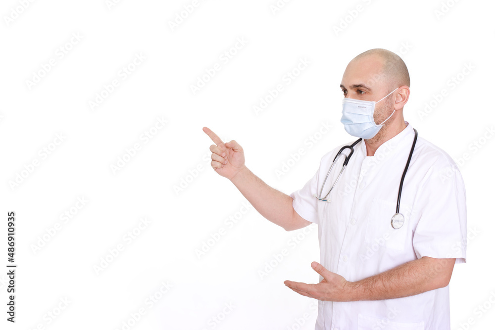 Middle-aged doctor in a white robe and with a stethoscope around his neck on a white background pointing to the left Middle-aged doctor in a white robe and with a stethoscope around his neck on a white background pointing to the left