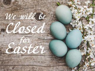 Signboard with the inscription We will be closed for Easter. Easter eggs painted with colorful paints. Closeup, indoors, no people. Congratulations for loved ones, relatives, friends, colleagues