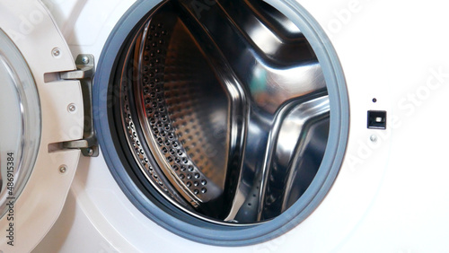 Close-up of a beautiful washing machine drum with the opened front door © Stockah