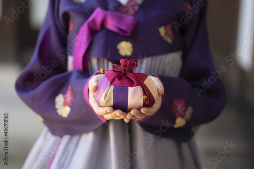Woman in Korean traditional clothes holding lucky bag