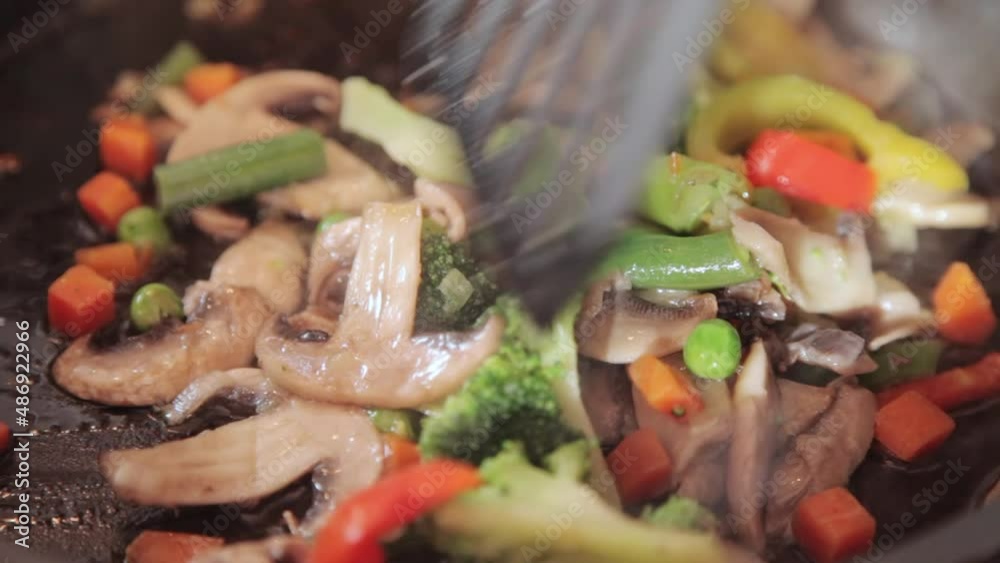 The vegetables are fried and stirred with a spatula The vegetables are fried and stirred with a spatula