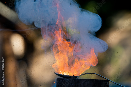 Flame explosion of Cracker gunpowder in a spoon with a lot of smoke bubbling and pushing upward