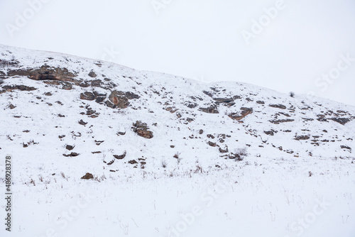Rocky hill covered by snow , winter scenery 