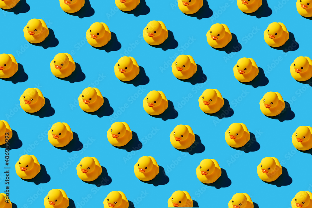 Yellow rubber duck toys pattern on seamless blue background.