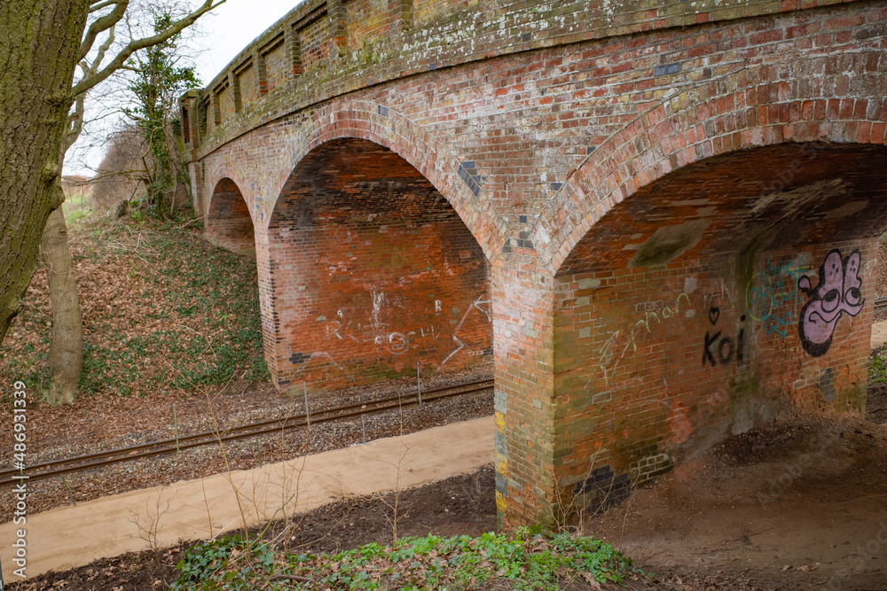 Bridge constructed from red brick over the Bure Valley Railway line in the Norfolk countryside