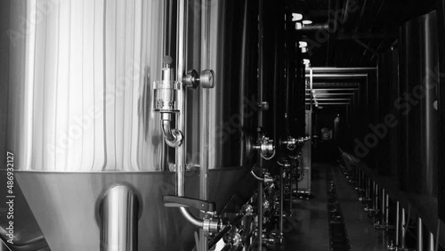 Craft beer production line in private microbrewery. Modern beer plant with brewering kettles, tubes and tanks made of stainless steel photo