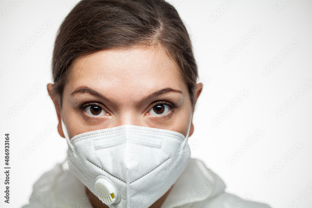 Female caucasian medical worker wearing PPE N95 face mask and protective suit,closeup portrait Female caucasian medical worker wearing PPE N95 face mask and protective suit,closeup portrait