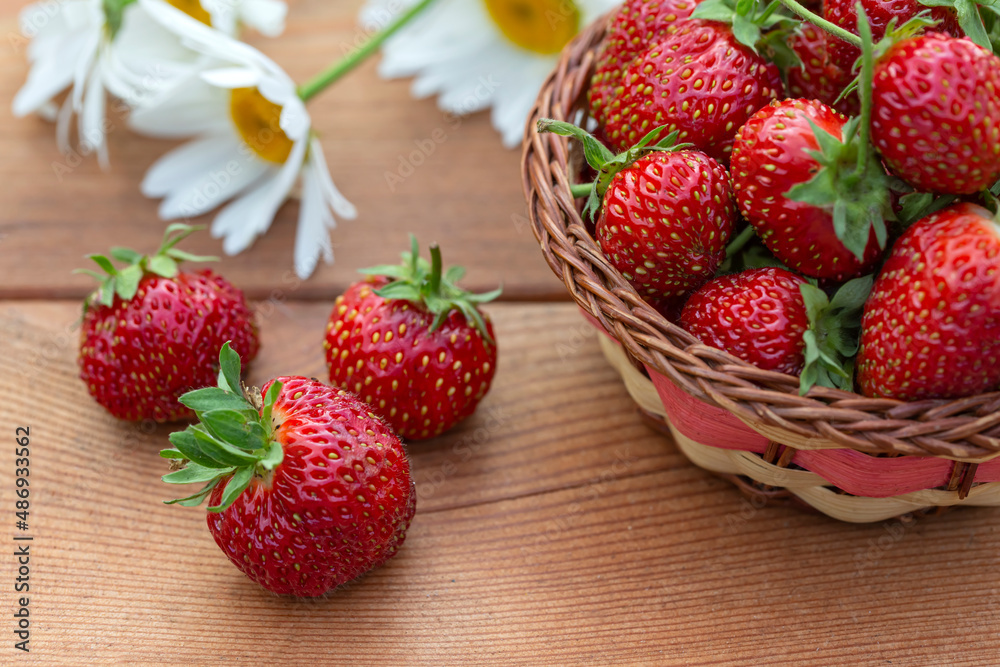 Ripe juicy strawberries on a wooden table. Healthy food rich in fiber, vitamins, antioxidants. Vegetarian food.