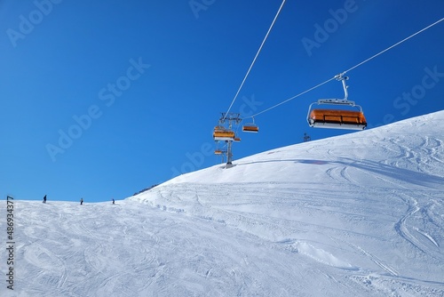 Ski lift in a ski resort in the german alps. Skiers on a ski slope on a sunny winter day.