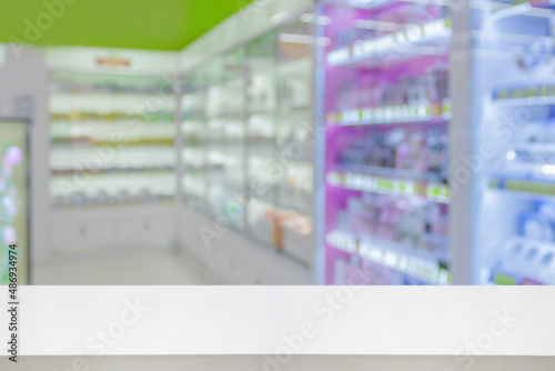 Empty white counter with pharmacy drugstore shelves blurred background