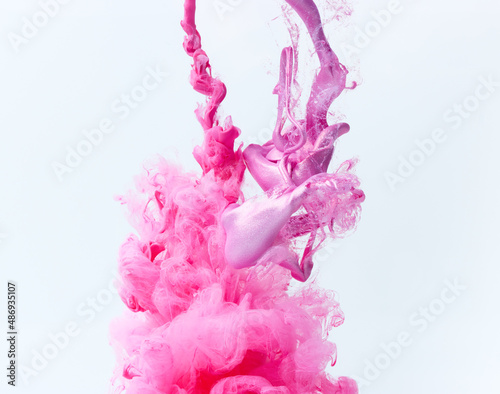 Pink paints splash curves in water on white. Acrylic paint drop background. Abstract colors swirl texture