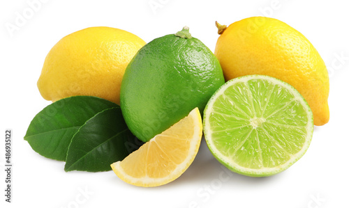 Fresh ripe lemons, limes and green leaves on white background