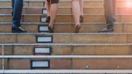 Cropped picture of business people walking up the stairs. Teamwork success concept.