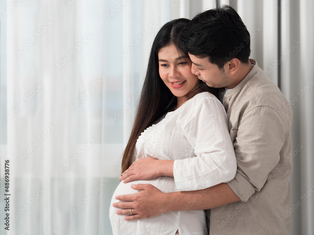 Portrait of Asian couple hugging and both putting hands on tummy of pregnant woman. Portrait of Asian couple hugging and both putting hands on tummy of pregnant woman.