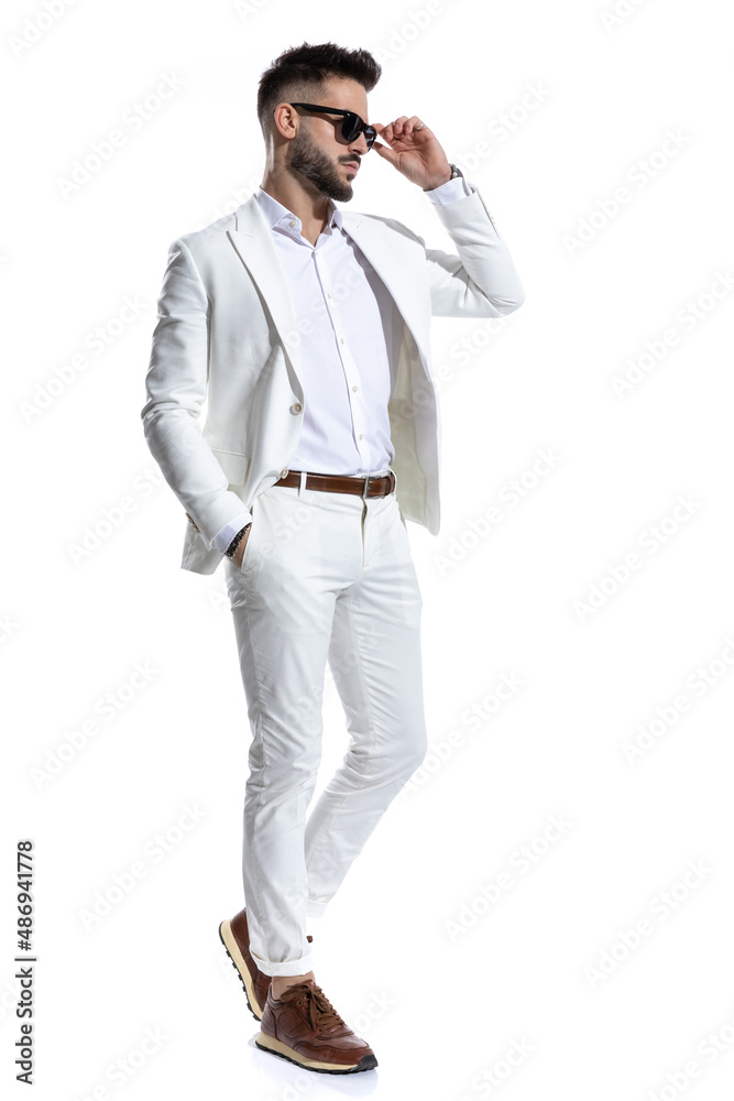side view of unshaved young man looking to side and arranging glasses side view of unshaved young man looking to side and arranging glasses