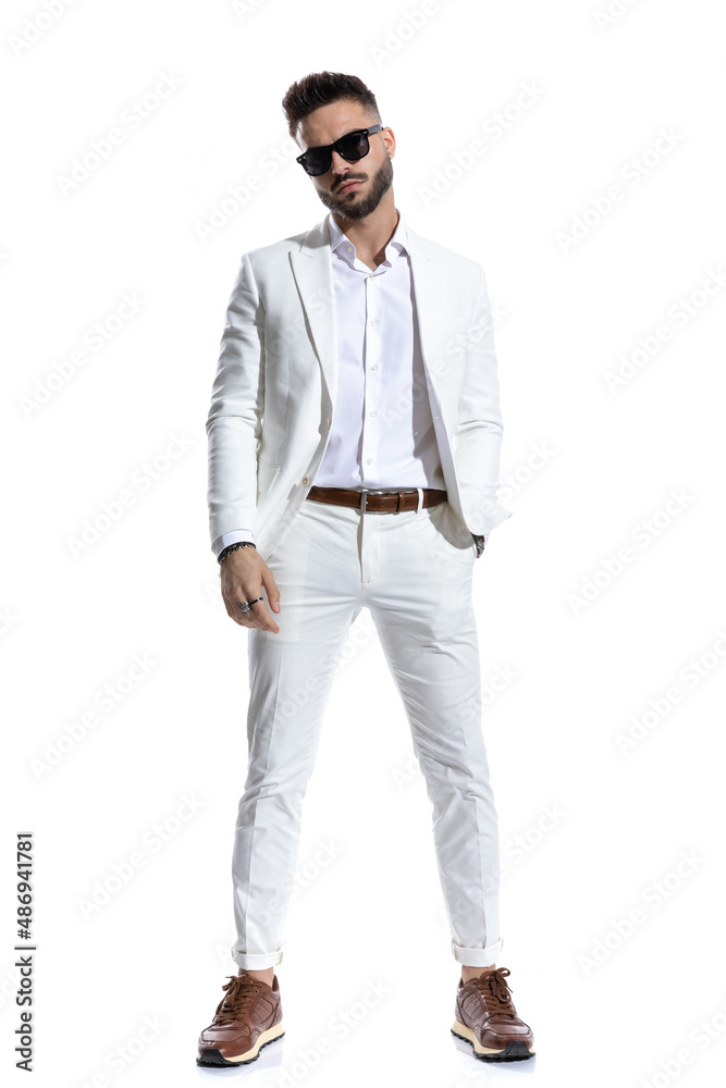 bearded businessman with eyeglasses holding hand in pocket and posing